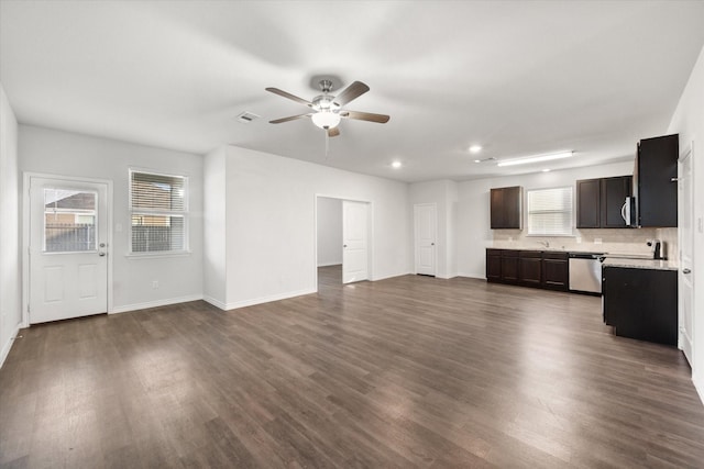 unfurnished living room with ceiling fan, a healthy amount of sunlight, dark hardwood / wood-style floors, and sink