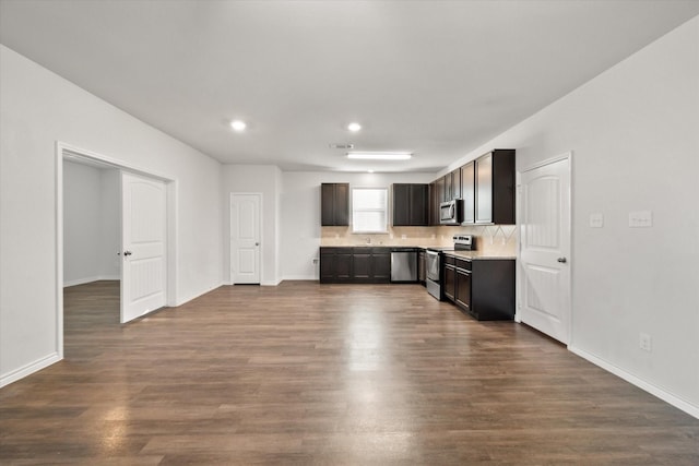 kitchen with dark hardwood / wood-style flooring, stainless steel appliances, dark brown cabinets, and tasteful backsplash