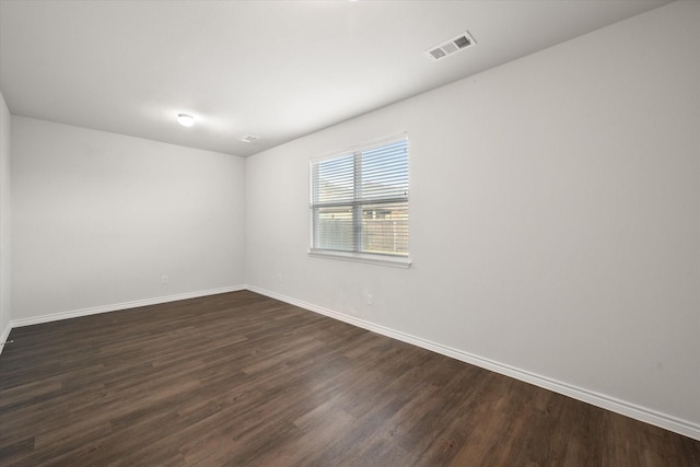 spare room featuring dark wood-type flooring