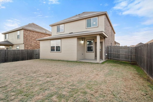 rear view of house with a patio area and a lawn