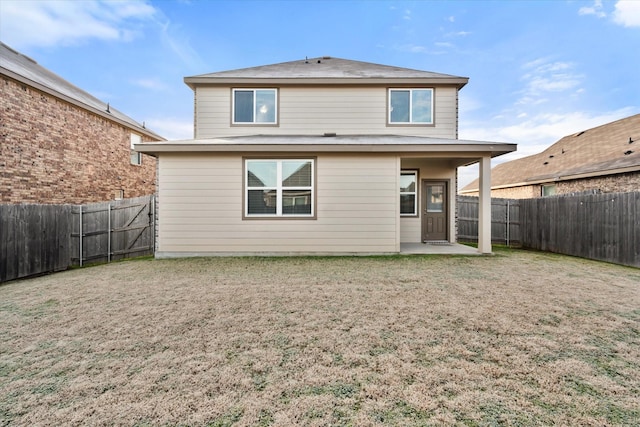 rear view of house with a lawn and a patio