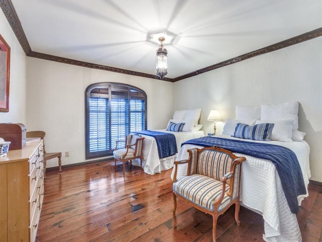 bedroom with dark hardwood / wood-style flooring and crown molding