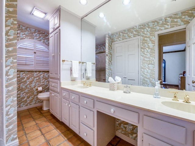 bathroom featuring toilet, crown molding, and vanity