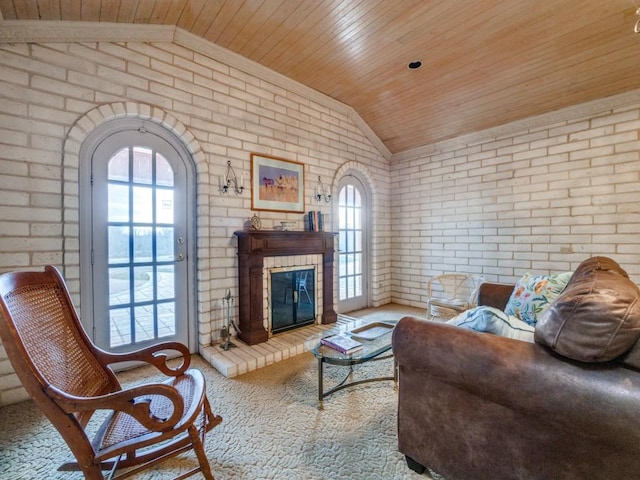 living room featuring vaulted ceiling, a wealth of natural light, brick wall, and a fireplace