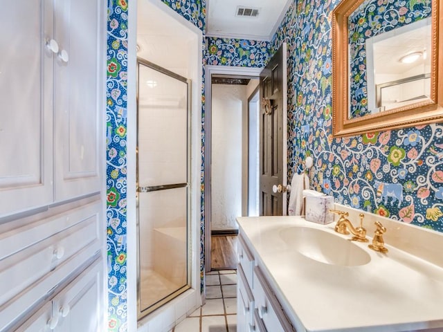 bathroom featuring walk in shower, vanity, tile patterned floors, and ornamental molding