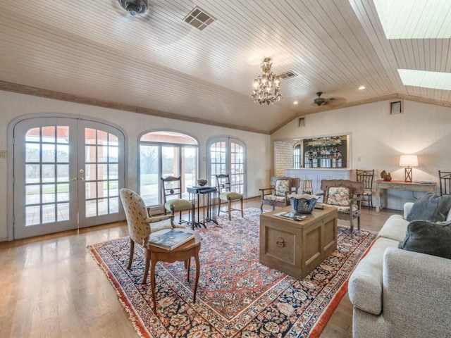 living room with wood-type flooring, wood ceiling, ceiling fan with notable chandelier, and french doors