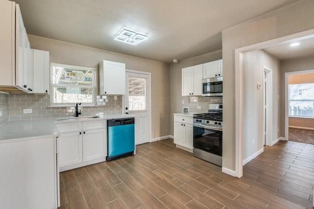 kitchen featuring tasteful backsplash, light hardwood / wood-style floors, sink, white cabinetry, and stainless steel appliances