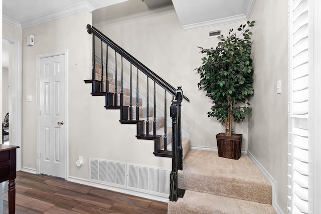 stairs featuring baseboards, visible vents, ornamental molding, and wood finished floors