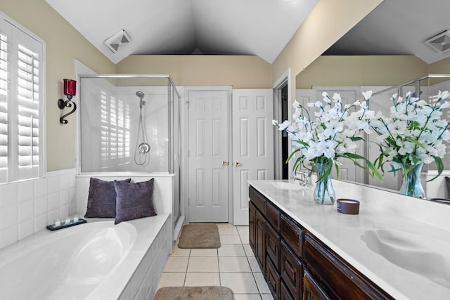 full bathroom with double vanity, visible vents, vaulted ceiling, a shower stall, and tile patterned flooring