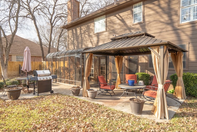 rear view of property featuring a patio area, fence, a chimney, and a gazebo