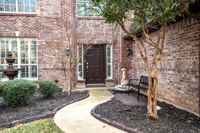 doorway to property featuring brick siding