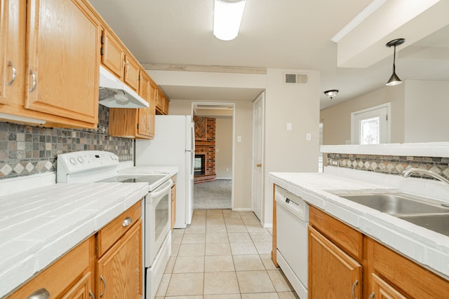 kitchen featuring tile countertops, pendant lighting, decorative backsplash, and white appliances