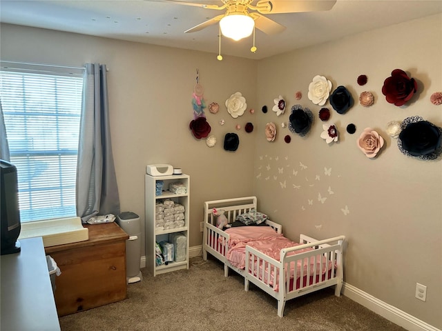 carpeted bedroom with ceiling fan and baseboards