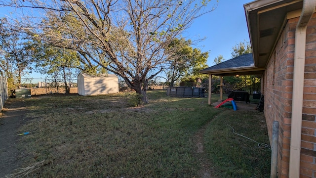 view of yard with an outdoor structure, a swimming pool, and a storage shed