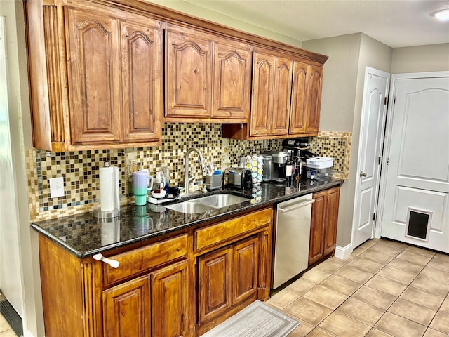 kitchen with dark stone counters, brown cabinets, dishwasher, and a sink