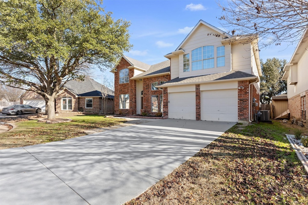 view of front of property with a garage, a front yard, and central AC unit