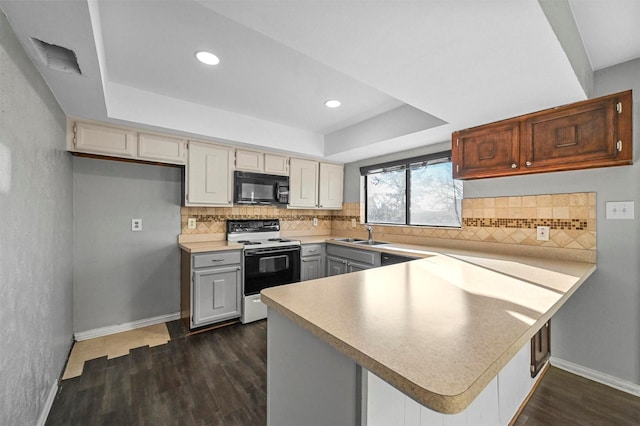 kitchen with sink, dark hardwood / wood-style floors, a raised ceiling, kitchen peninsula, and range with electric cooktop