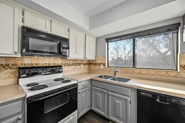 kitchen with white cabinetry, gray cabinetry, tasteful backsplash, black appliances, and sink