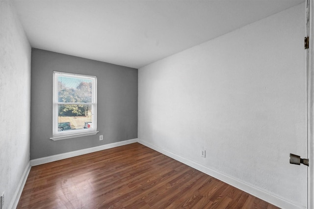 empty room with dark hardwood / wood-style flooring