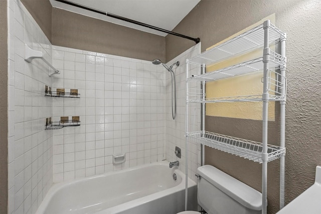 bathroom featuring toilet and tiled shower / bath