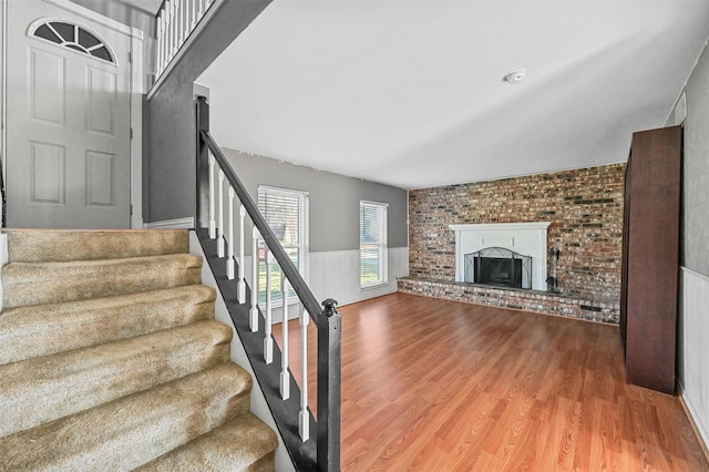 stairs featuring a fireplace and hardwood / wood-style flooring