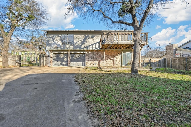 view of front of property featuring a garage, a front lawn, and a wooden deck