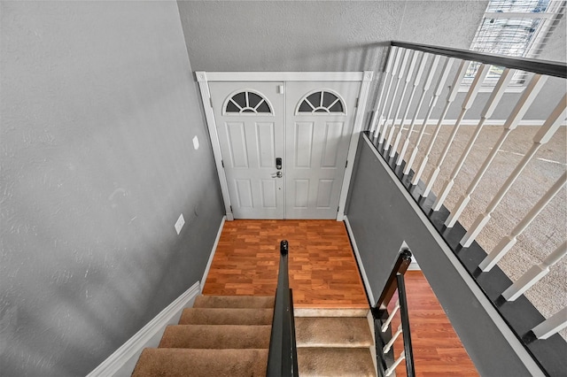 staircase with hardwood / wood-style flooring and a high ceiling