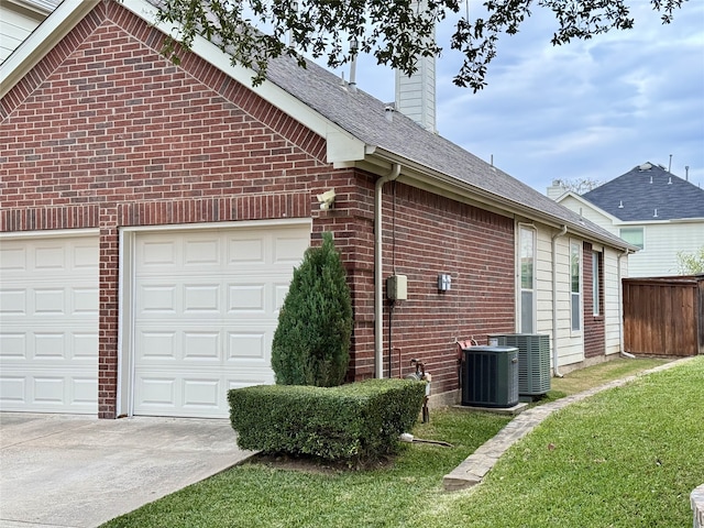 view of side of property featuring central AC unit and a yard