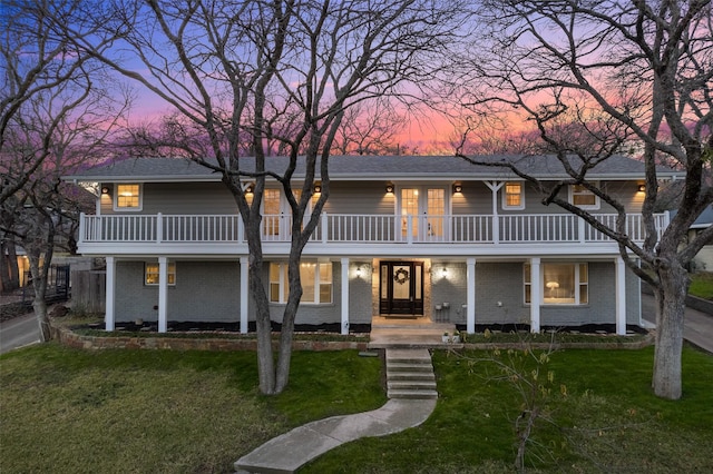 view of front of property with a lawn and a balcony