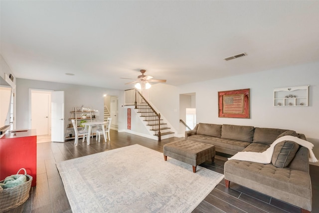 living room with ceiling fan and dark hardwood / wood-style flooring