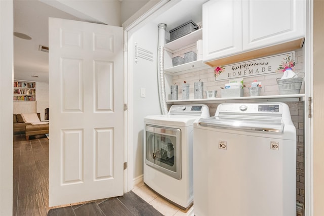 laundry room with washing machine and dryer and cabinets