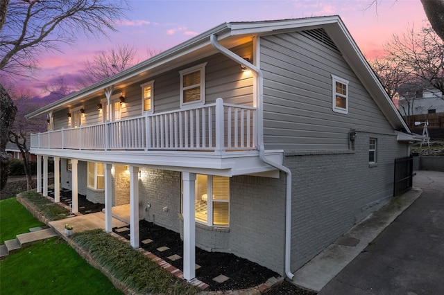 property exterior at dusk featuring a balcony