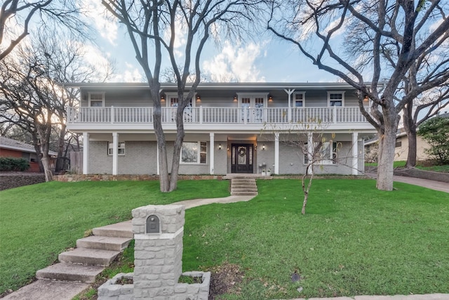 view of front facade featuring a front lawn, a balcony, and a porch