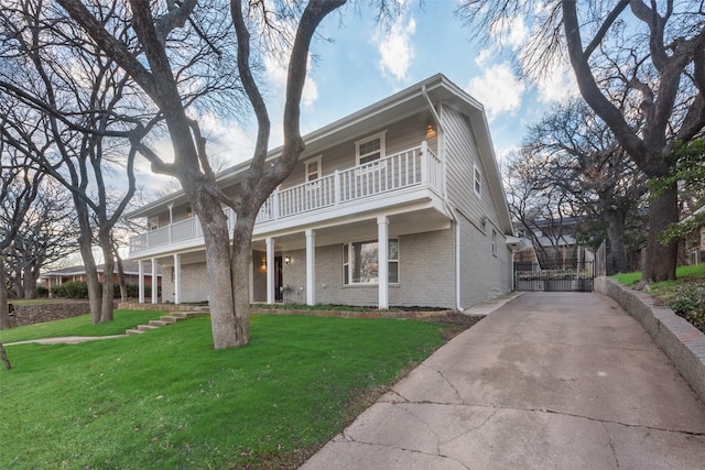 view of front of house featuring a front lawn and a balcony