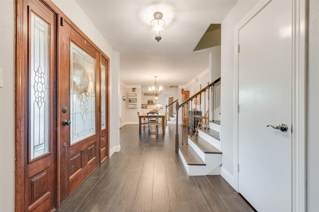 foyer with dark hardwood / wood-style flooring and an inviting chandelier