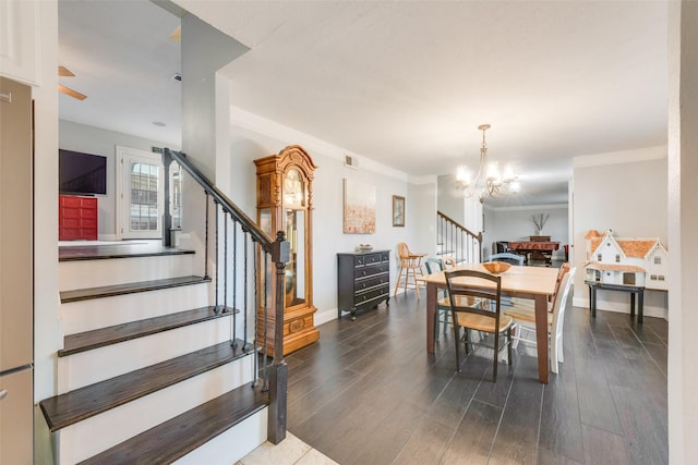 dining space with crown molding, dark hardwood / wood-style flooring, and an inviting chandelier