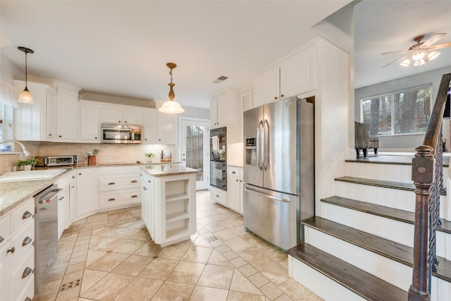 kitchen featuring white cabinetry, pendant lighting, stainless steel appliances, and a kitchen island