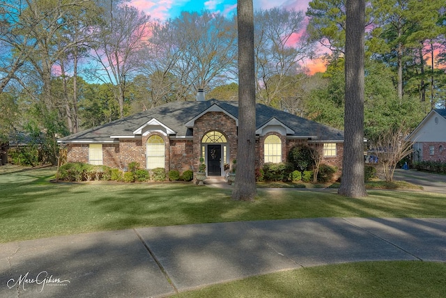 ranch-style home with a yard