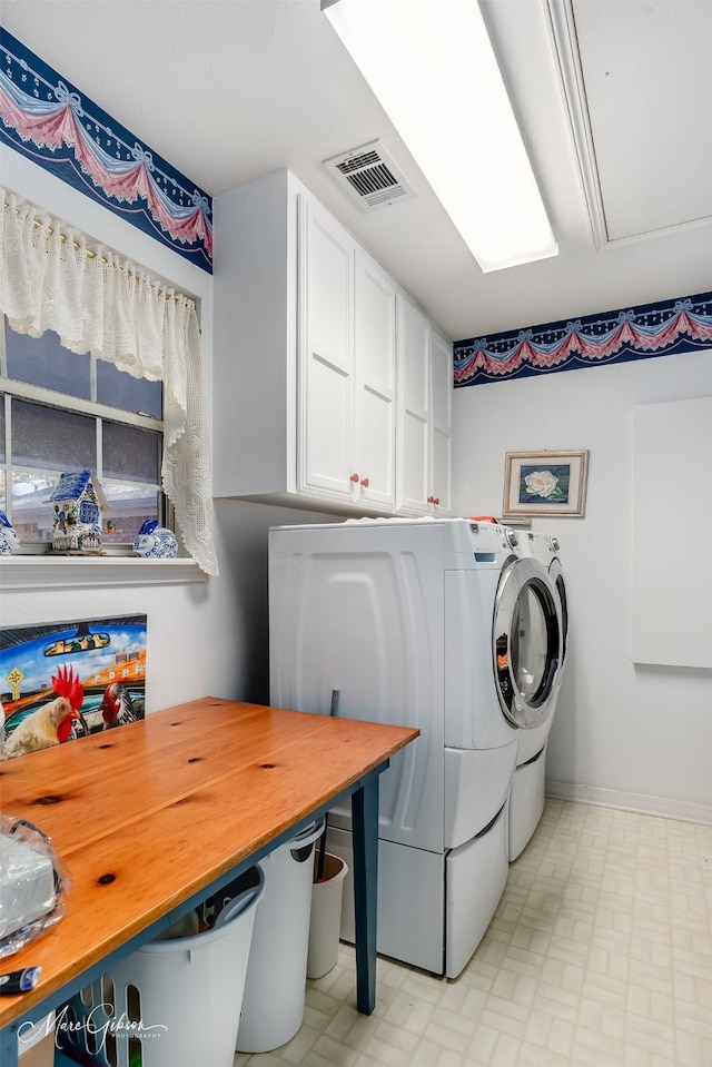 laundry area with cabinets and washing machine and clothes dryer