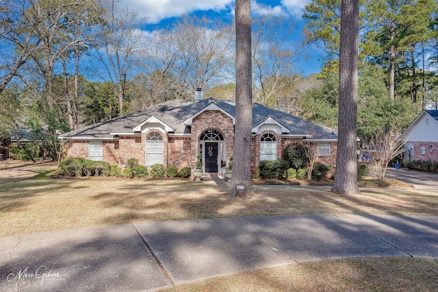 single story home featuring a front lawn