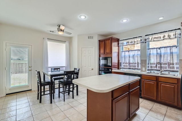 kitchen with ceiling fan, a center island, black appliances, sink, and light tile patterned flooring