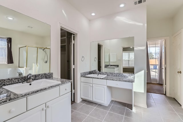 bathroom featuring tile patterned floors, vanity, and a shower with shower door