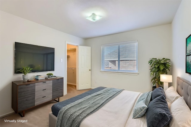 bedroom featuring light carpet, a closet, and a walk in closet