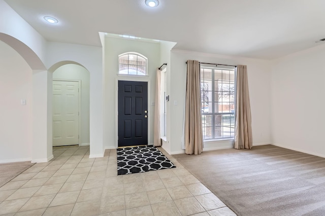 carpeted foyer entrance with crown molding