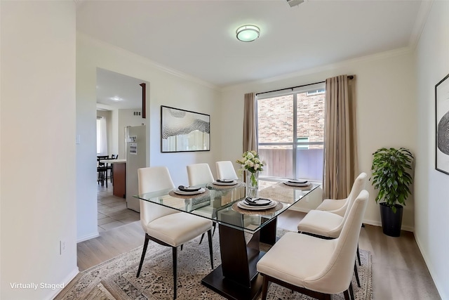 dining room featuring ornamental molding and light hardwood / wood-style flooring