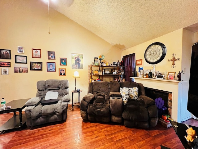 living room featuring lofted ceiling, a textured ceiling, and hardwood / wood-style floors