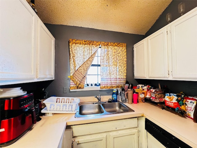 kitchen with a textured ceiling, white cabinets, dishwasher, lofted ceiling, and sink