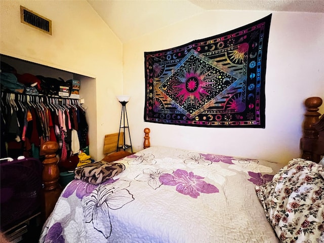 bedroom with lofted ceiling, a closet, and a textured ceiling