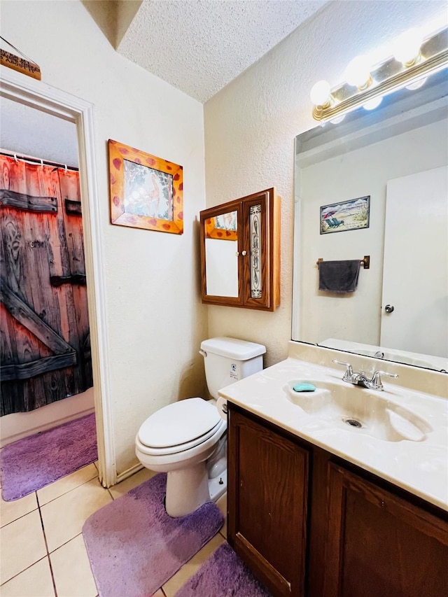 bathroom with toilet, vanity, tile patterned floors, and a textured ceiling