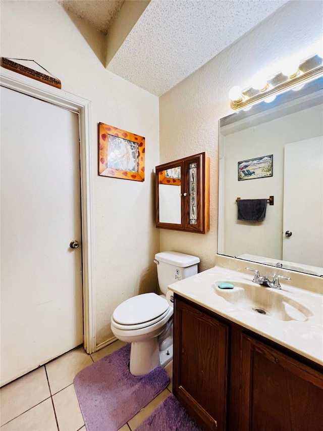 bathroom with a textured ceiling, toilet, tile patterned flooring, and vanity